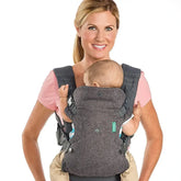 Woman wearing baby in All Seasons Newborn Front Facing Wrap Carrier in gray with secure straps and breathable fabric