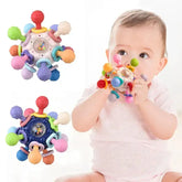 Baby playing with colorful rotating rattle ball and teething sensory toy for baby development and motor skills.