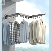 Wall-mounted 3-foldable aluminum alloy clothes drying rack holding multiple shirts, space-saving and durable design.