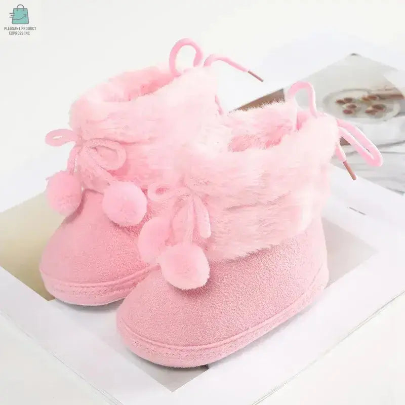 Pink baby winter furry snow boots with buckle strap and pom-pom accents for first walkers